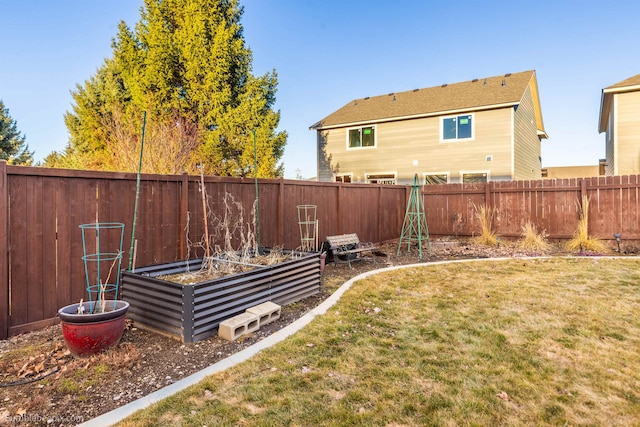 view of yard featuring a fenced backyard and a garden