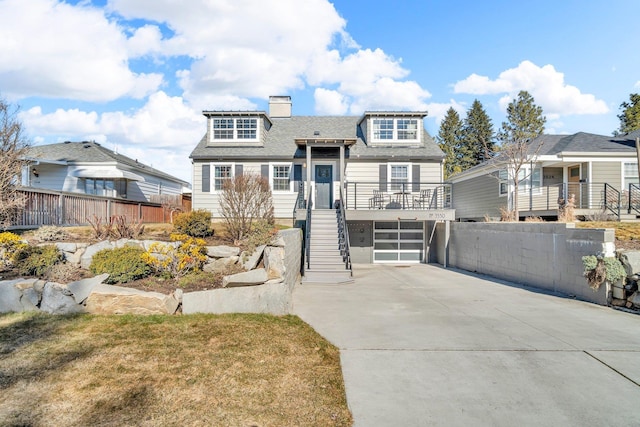 view of front of home with an attached garage, fence, stairway, and concrete driveway