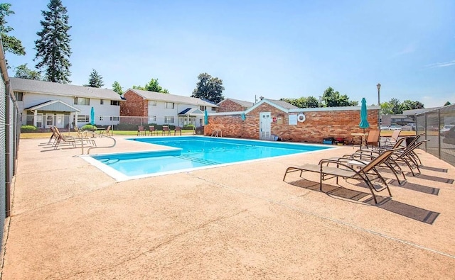 pool with a residential view, a patio area, and fence