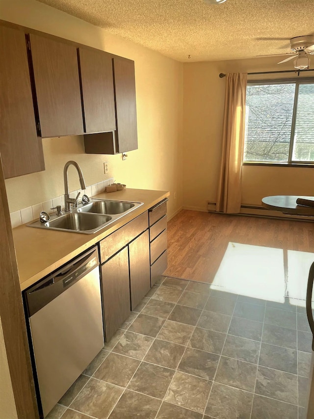 kitchen featuring a textured ceiling, ceiling fan, a sink, light countertops, and dishwasher