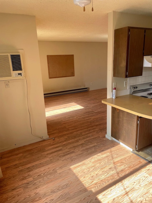 kitchen featuring extractor fan, a baseboard heating unit, electric stove, light wood finished floors, and tasteful backsplash