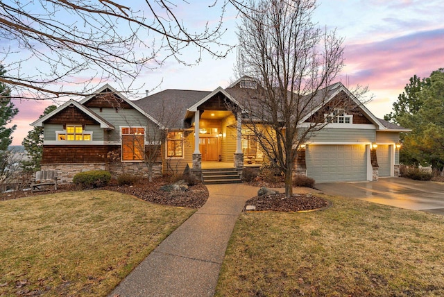 craftsman-style home with a yard, stone siding, and driveway