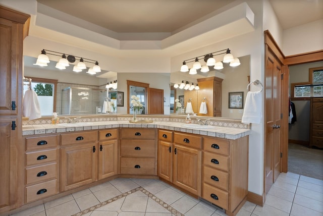 bathroom with a stall shower, a sink, and tile patterned floors