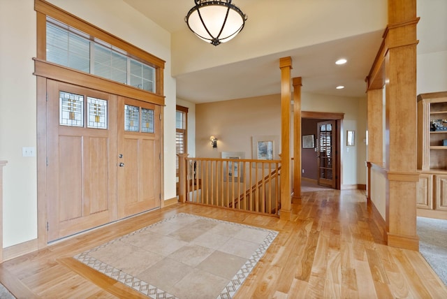 foyer featuring light wood-type flooring, decorative columns, baseboards, and recessed lighting