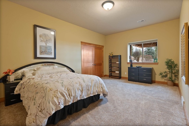 bedroom featuring light carpet, baseboards, visible vents, a textured ceiling, and a closet