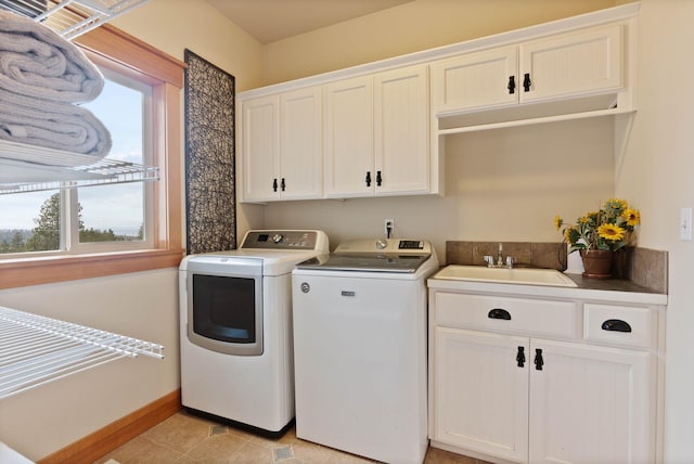 laundry room with light tile patterned floors, cabinet space, a sink, independent washer and dryer, and baseboards