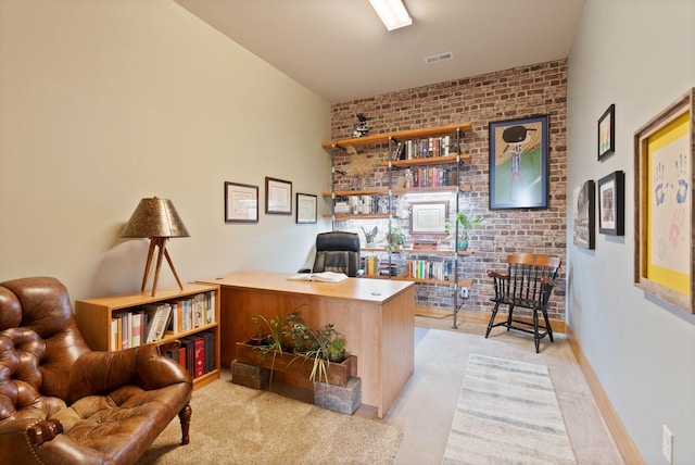 home office featuring light carpet, brick wall, visible vents, and baseboards