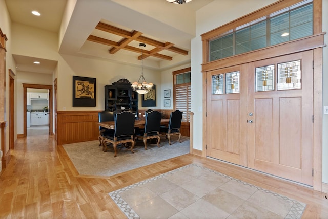 entryway featuring recessed lighting, a notable chandelier, coffered ceiling, beam ceiling, and light wood finished floors