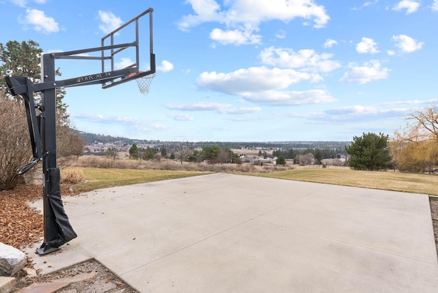 view of basketball court with a yard and basketball hoop