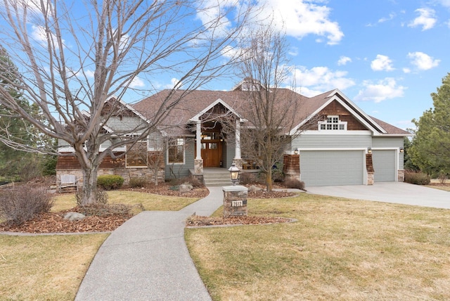 craftsman-style house featuring a garage, a front yard, stone siding, and driveway