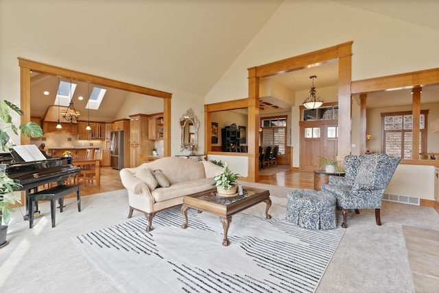 living room featuring high vaulted ceiling, a skylight, visible vents, and recessed lighting