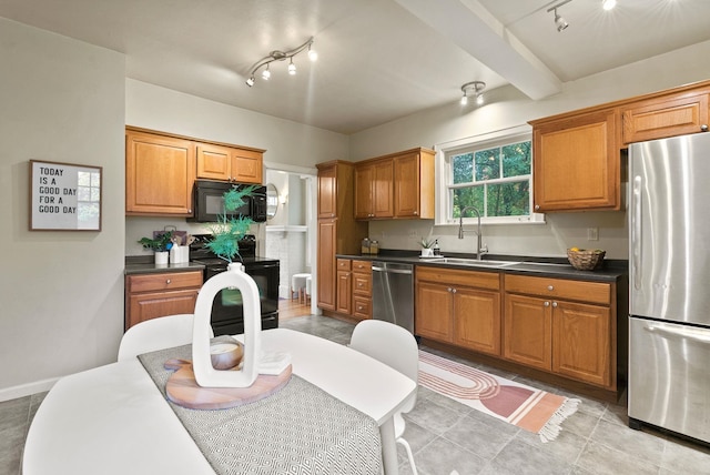 kitchen with dark countertops, black appliances, brown cabinetry, and a sink