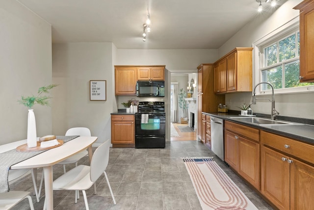 kitchen featuring brown cabinetry, dark countertops, a sink, and black appliances