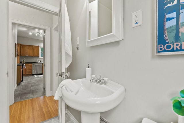 half bathroom with a sink and wood finished floors