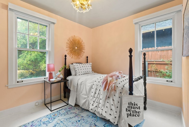 bedroom featuring an inviting chandelier and baseboards