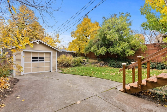 detached garage with fence and concrete driveway