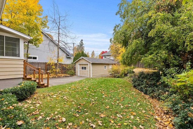 view of yard featuring an outbuilding, fence, and a detached garage