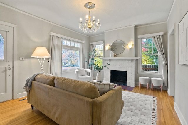 living room featuring ornamental molding, a fireplace, plenty of natural light, and light wood finished floors