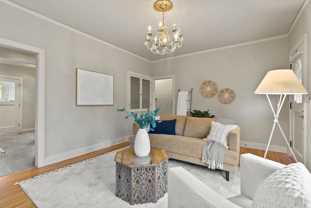 living room with a chandelier, crown molding, baseboards, and wood finished floors