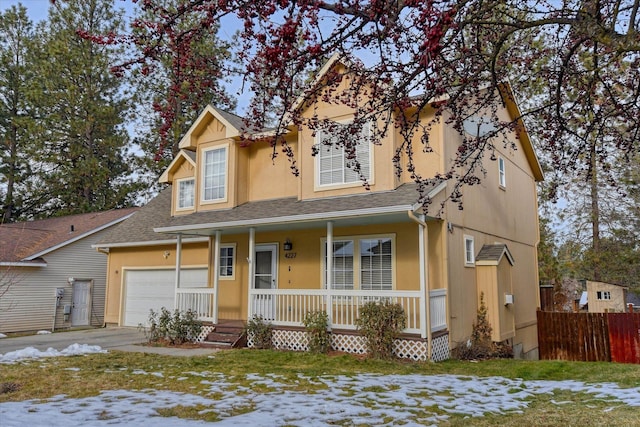 traditional-style house featuring covered porch, a garage, fence, roof with shingles, and stucco siding