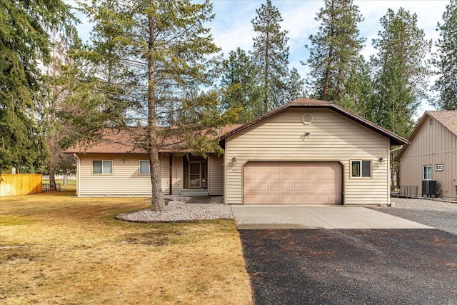 single story home with central AC, an attached garage, driveway, and a front yard