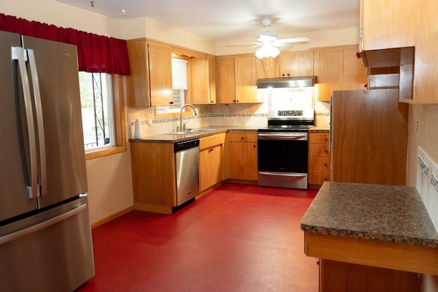 kitchen featuring stainless steel appliances, a sink, exhaust hood, baseboards, and tasteful backsplash