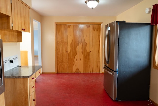 kitchen with dark countertops, baseboards, and freestanding refrigerator