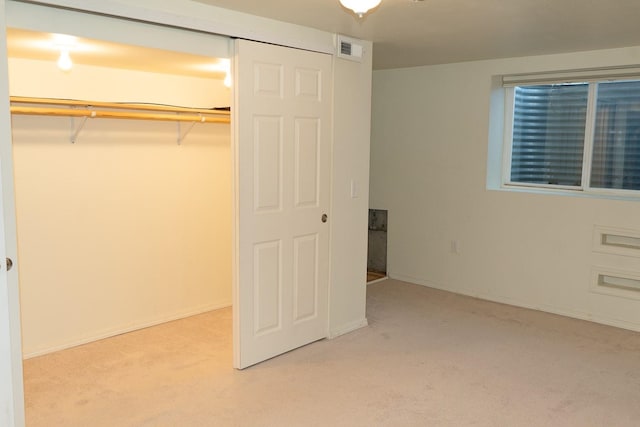 unfurnished bedroom with carpet floors, baseboards, visible vents, and a closet