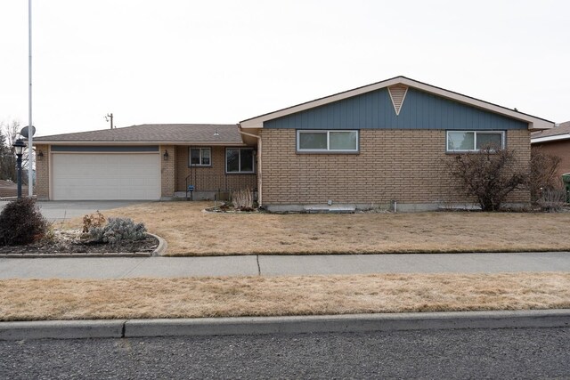 view of front facade with a garage, driveway, and brick siding