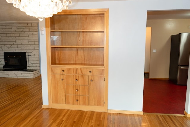 interior space featuring a fireplace, baseboards, and wood finished floors