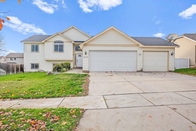 view of front of house featuring roof with shingles, a front yard, fence, a garage, and driveway