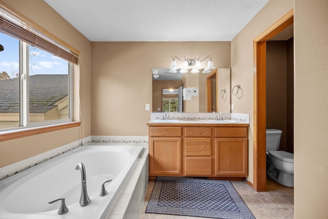 bathroom with toilet, double vanity, a sink, and a bath