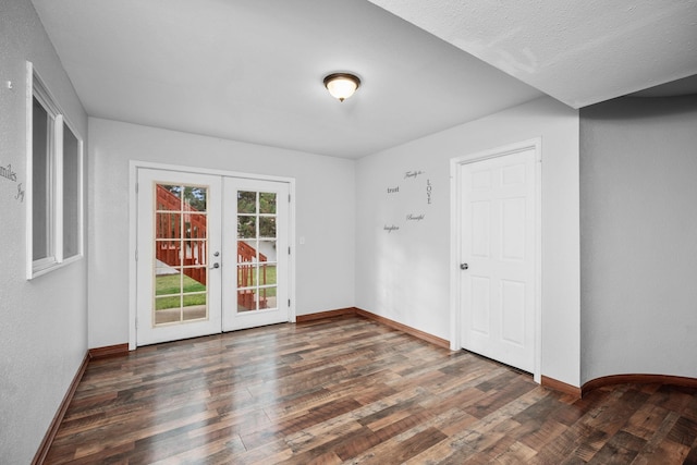 spare room with baseboards, wood finished floors, and french doors