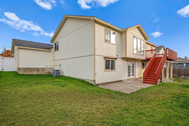 rear view of property featuring a yard, stairway, fence, and a gate