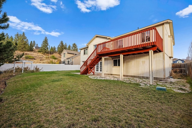 rear view of property featuring a fenced backyard, stairway, a wooden deck, and a yard