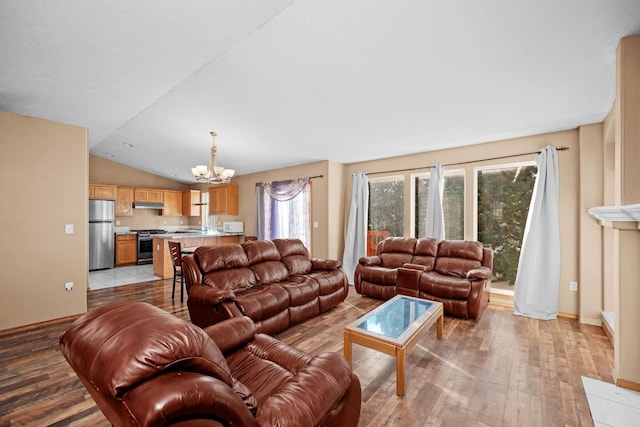 living area with light wood-type flooring, a notable chandelier, lofted ceiling, and baseboards