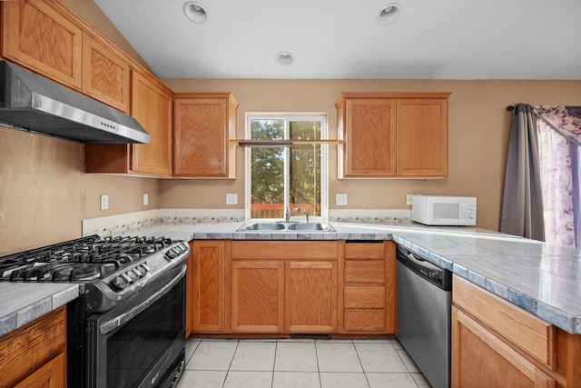 kitchen featuring light countertops, appliances with stainless steel finishes, a sink, a peninsula, and under cabinet range hood