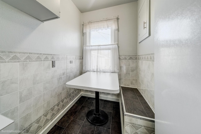 bathroom with tile patterned floors, tile walls, and wainscoting