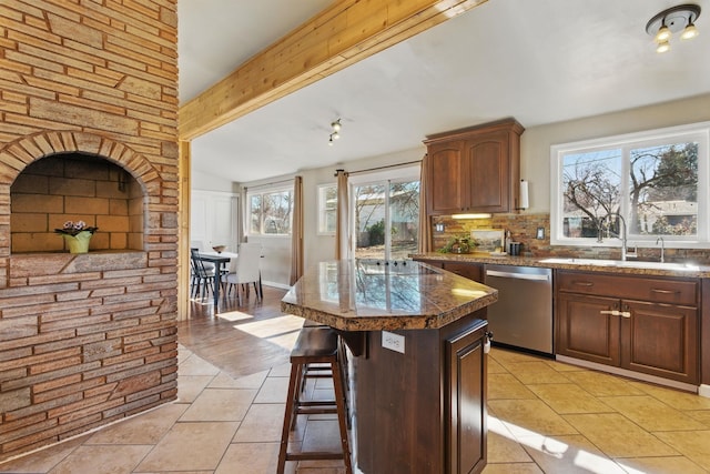 kitchen with tile countertops, light tile patterned flooring, a breakfast bar, a sink, and stainless steel dishwasher