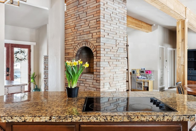 kitchen with tile counters, beamed ceiling, and black electric cooktop