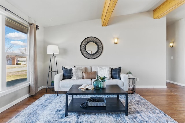 living area featuring beam ceiling, baseboards, and wood finished floors