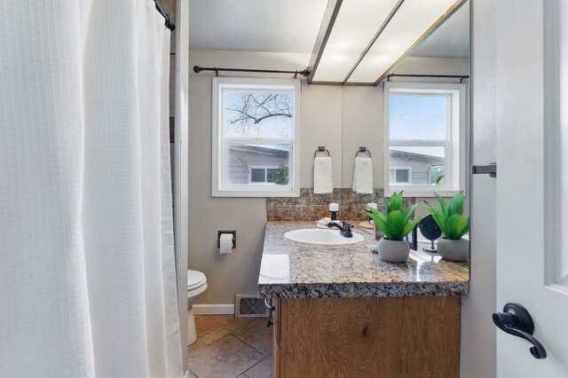 bathroom with tile patterned flooring, toilet, visible vents, vanity, and baseboards