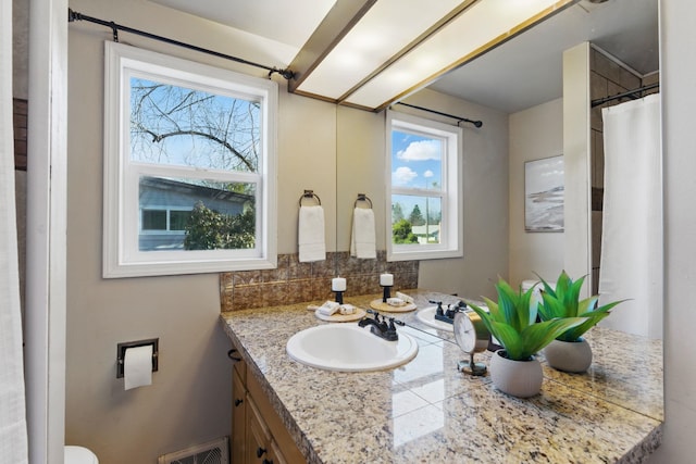 full bathroom featuring a healthy amount of sunlight, visible vents, backsplash, and vanity