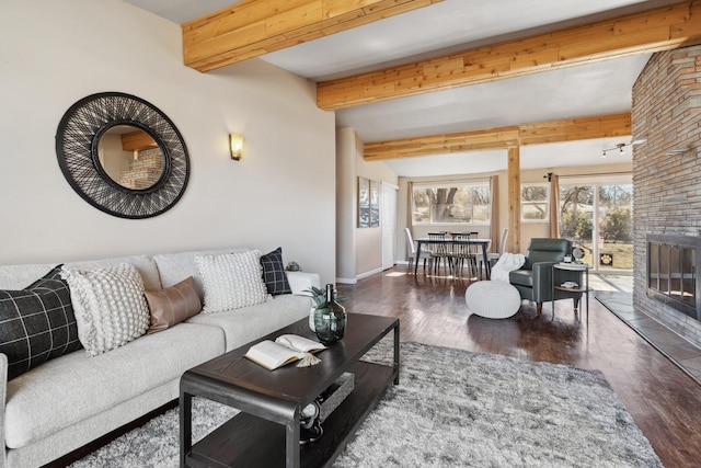 living room with a large fireplace, vaulted ceiling with beams, baseboards, and wood finished floors