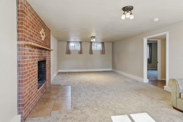 unfurnished living room with a brick fireplace, baseboards, and carpet flooring