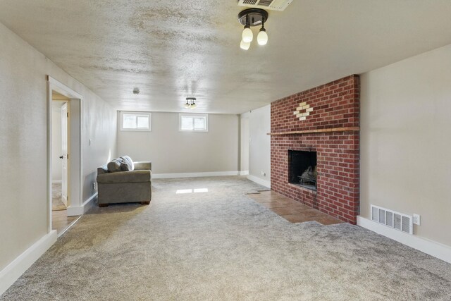 unfurnished living room featuring visible vents, baseboards, carpet, a textured ceiling, and a brick fireplace