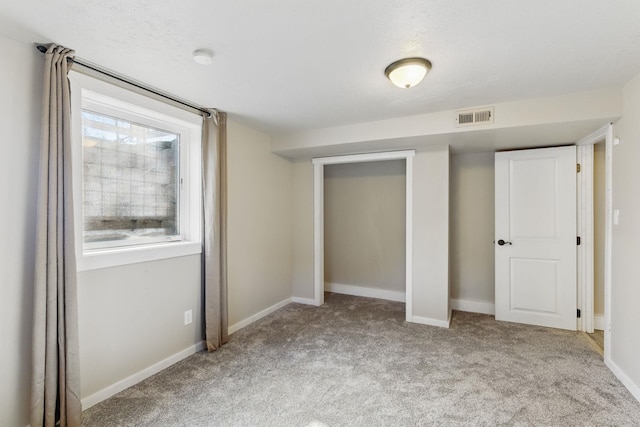 unfurnished bedroom featuring carpet, visible vents, and baseboards