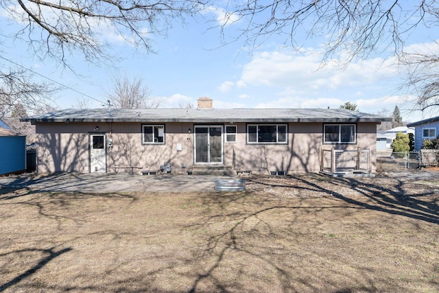 rear view of property with a patio area, fence, and a chimney