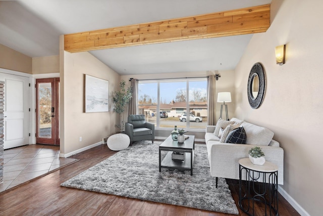 living room featuring lofted ceiling with beams, baseboards, and wood finished floors