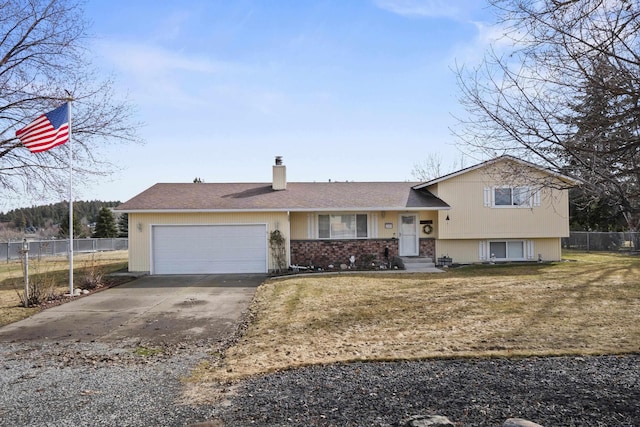 split level home with a chimney, concrete driveway, an attached garage, fence, and a front lawn